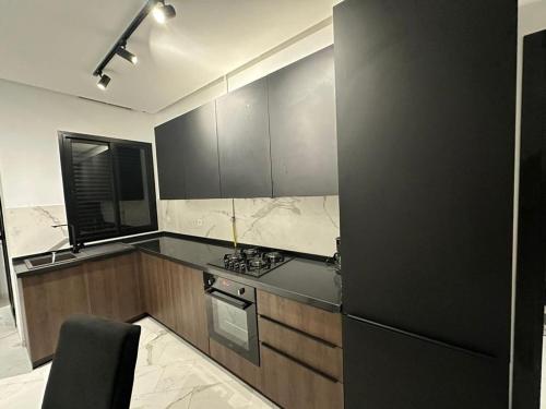 a kitchen with black cabinets and a black refrigerator at Luxury appartement in La Marsa