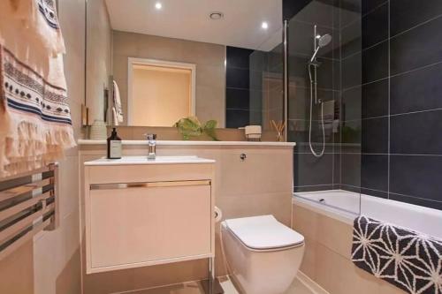 a bathroom with a toilet and a sink and a tub at Kings Cross Walking Distance Luxury Private Garden House in London