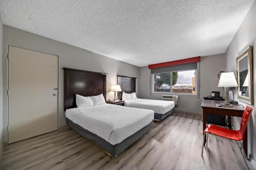 a hotel room with two beds and a desk and a door at Royal Pagoda Motel Dodger Stadium in Los Angeles