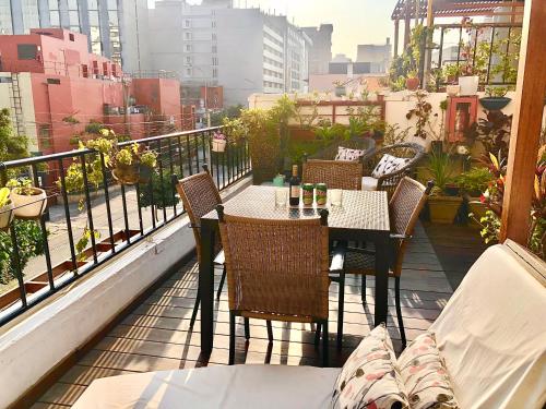 a patio with a table and chairs on a balcony at La Casa del Viajero in Lima