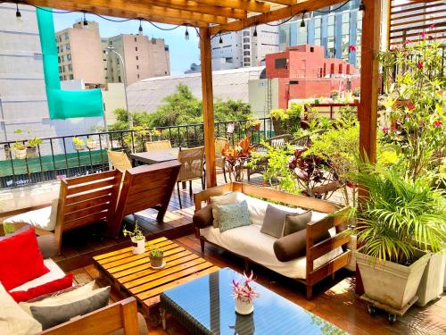 een patio met een bank en stoelen op een balkon bij La Casa del Viajero in Lima