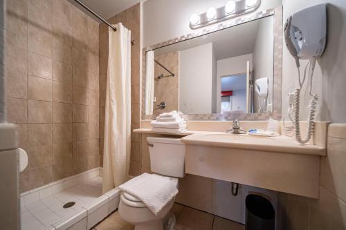 a bathroom with a sink and a toilet and a mirror at Royal Pagoda Motel Dodger Stadium in Los Angeles