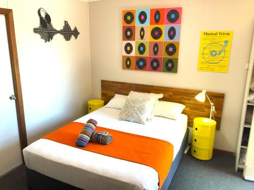 a bedroom with a bed with an orange blanket at Acacia Motel in Chinchilla