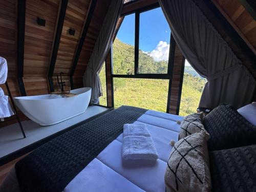 a bedroom with a tub and a sink in a room at Cabana The Wild Urubici in Urubici