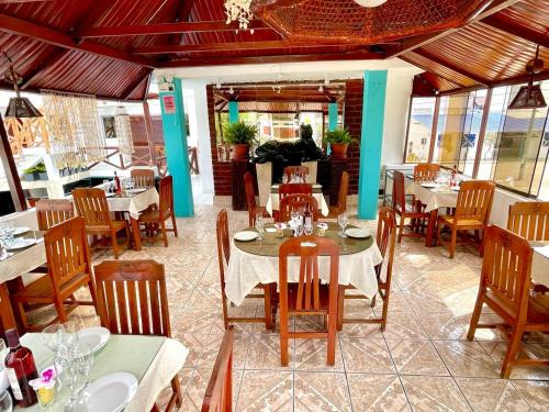 a dining room with tables and chairs in a restaurant at Hostal Ocean Pacifico in Punta Negra