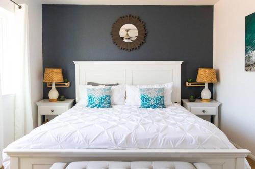 a bedroom with a large white bed with blue pillows at Cali Condo+BBQ+MemoryFoamBeds+12min to Beach in San Juan Capistrano