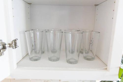 four empty glass vases sitting on a shelf at Cali Condo+BBQ+MemoryFoamBeds+12min to Beach in San Juan Capistrano