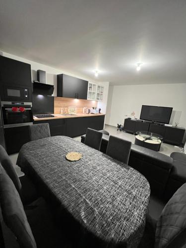 une pièce avec une table et des chaises et une cuisine dans l'établissement Dugny Airways - Le Bourget, à Dugny