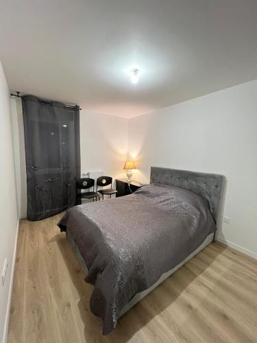 une chambre avec un lit, une table et des chaises dans l'établissement Dugny Airways - Le Bourget, à Dugny