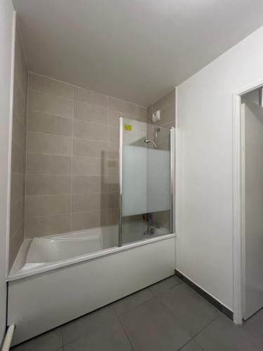 een witte badkamer met een bad en een douche bij Dugny Airways - Le Bourget in Dugny
