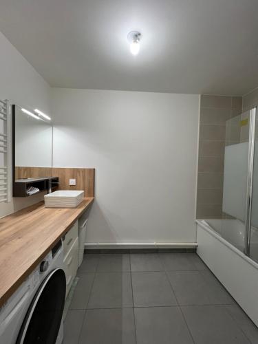 een badkamer met een wasmachine en een wastafel bij Dugny Airways - Le Bourget in Dugny