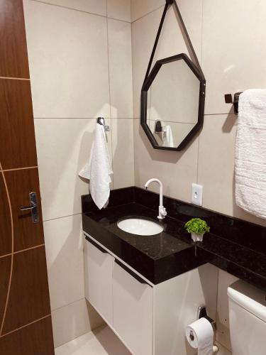 uma casa de banho com um lavatório e um espelho em Pousada Bouganville da Serra em Serra de São Bento