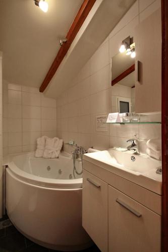 a white bathroom with a tub and a sink at Palatino Rooms & Apartments in Tripoli