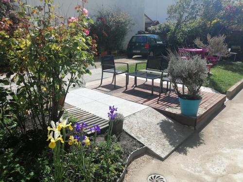un jardín con 2 sillas, una mesa y flores en Logement+parking proche métro - total autonome en Villejuif