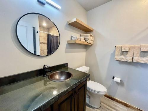 a bathroom with a sink and a toilet and a mirror at Angel Rock Rentals of Moab Unit 10 in Moab