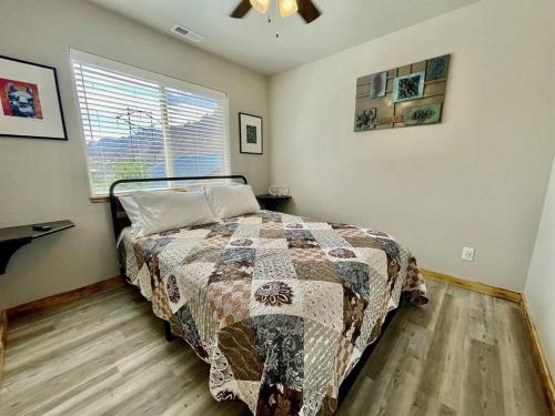 a bedroom with a bed with a quilt and a window at Angel Rock Rentals of Moab Unit 10 in Moab