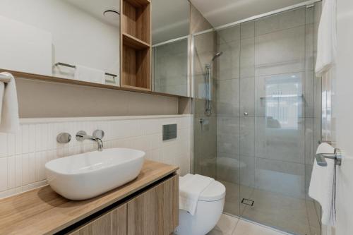 a bathroom with a sink and a toilet and a shower at Comfy 1-Bed Apt with Courtyard, Gym, BBQ & Parking in Kingston 