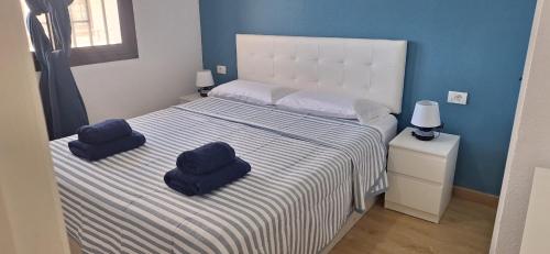 ein Schlafzimmer mit einem Bett mit zwei Kissen darauf in der Unterkunft Sasha Tenerife in Costa Del Silencio