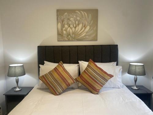 1 dormitorio con 1 cama con 2 lámparas en las mesas en E.C.A.S. Pitreavie Castle 2 Bed Executive Apartment, en Fife
