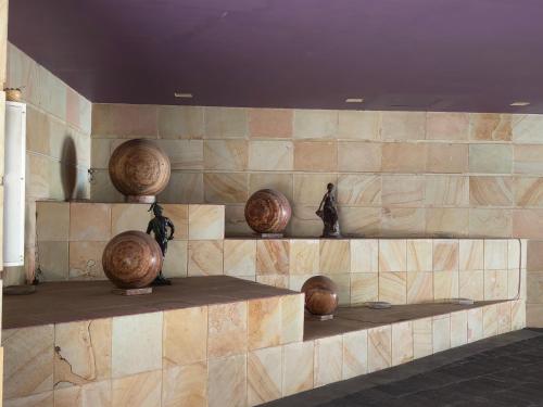 una pared de piedra con jarrones y esculturas expuestas en Hotel Max, en Ciudad de México