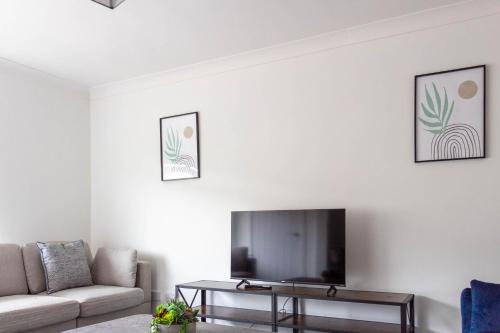 sala de estar con TV y sofá en Winton House en Glasgow