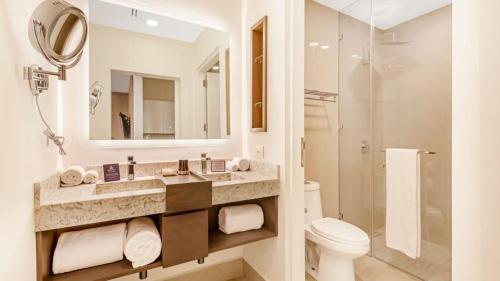 a bathroom with a sink and a toilet and a mirror at Voyage Vacation Club in Rosarito