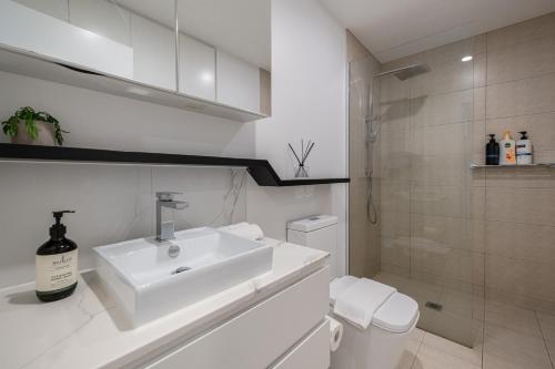 a white bathroom with a sink and a toilet at Clayton Beautiful 2br1ba Apartmentbalcony in Clayton North