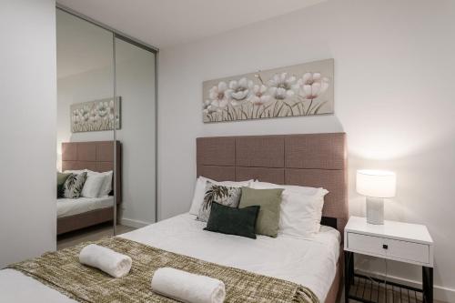 a bedroom with a large bed and a mirror at Clayton Beautiful 2br1ba Apartmentbalcony in Clayton North