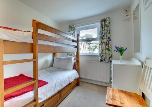 a bedroom with two bunk beds and a window at 12 New Street in Padstow