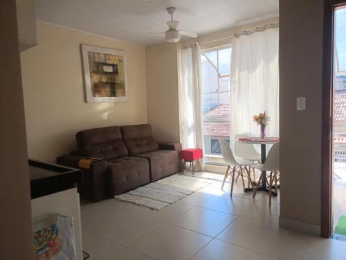 uma sala de estar com um sofá e uma mesa em Apartamento para temporada em Vitória