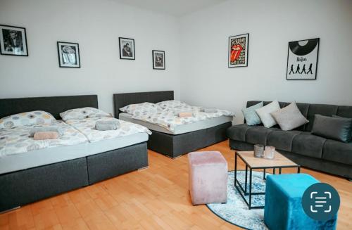een woonkamer met 2 bedden en een bank bij Raimond Apartment Top 27 in Wenen