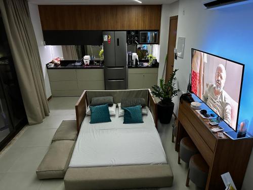 een woonkamer met een bank en een keuken bij Studio luxo na Barra para 4 Pessoas in Salvador