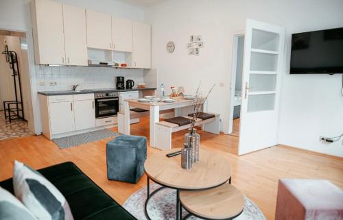 een woonkamer met een bank en een tafel en een keuken bij Raimond Apartment Top 27 in Wenen