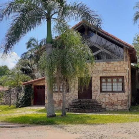 聖貝納迪諾的住宿－Cabaña Las Palmeras，前面有棕榈树的房子