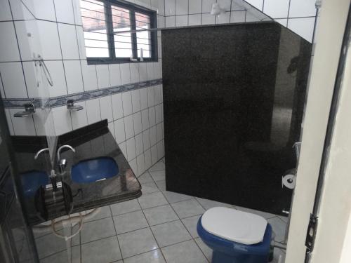 a bathroom with a blue toilet and a sink at Pedroca Hostel in Palmas
