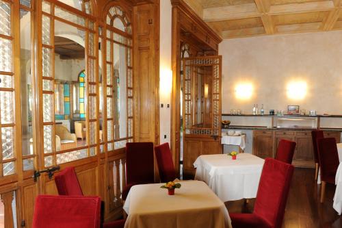 un comedor con 2 mesas y sillas rojas en Dimora del Barone, en Gattinara