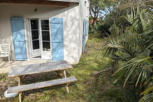 un banc en bois assis à l'extérieur d'une maison dans l'établissement Comfortable and nice house with a beautiful garden, à La Tranche-sur-Mer