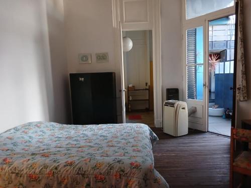 1 dormitorio con 1 cama y puerta al baño en Habitación en suite en el centro de Buenos Aires. en Buenos Aires
