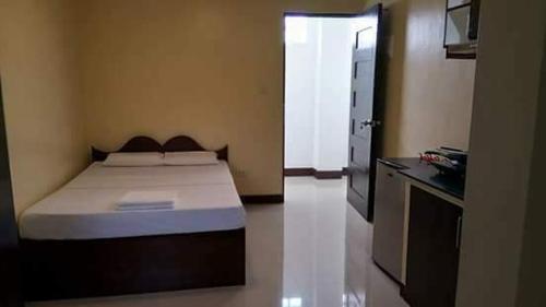 1 dormitorio pequeño con 1 cama y cocina en Argao Aballe Pension House/Apartelle en Argao