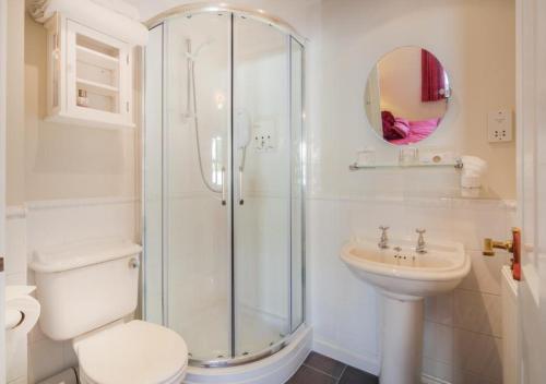 a bathroom with a shower and a toilet and a sink at Beach Mews in Torquay