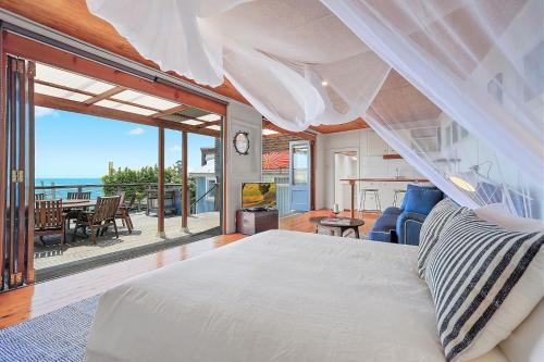um quarto com uma cama e vista para o oceano em Boatshed em Huskisson