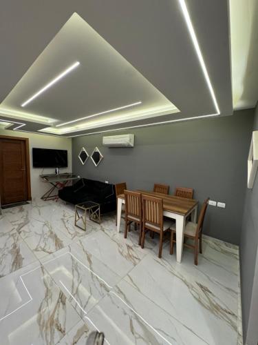 - un salon avec une table et des chaises dans l'établissement Bright apartment ( شقة واسعة من 3 غرف ), au Caire
