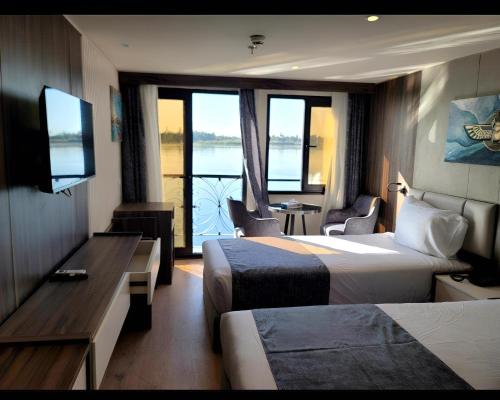 a hotel room with two beds and a view of the water at NILE CRUISE LUXOR & ASwAN نايل كروز الاقصر و اسوان in Luxor