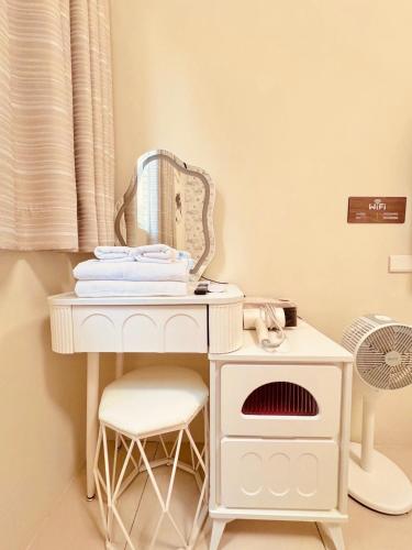 a white dressing table with a mirror and a fan at Xu Xu Homestay in Chiayi City