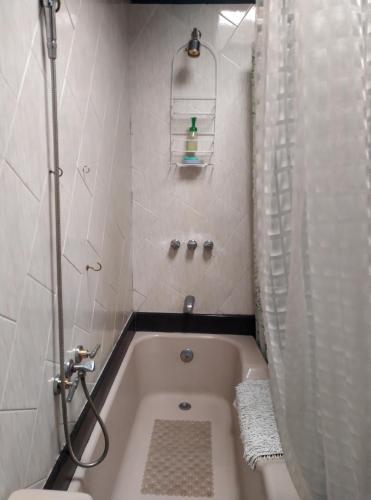 ein Bad mit einer Badewanne, einer Dusche und einem WC in der Unterkunft Casa del Aguacate Cumbaya - Tumbaco in Cumbayá
