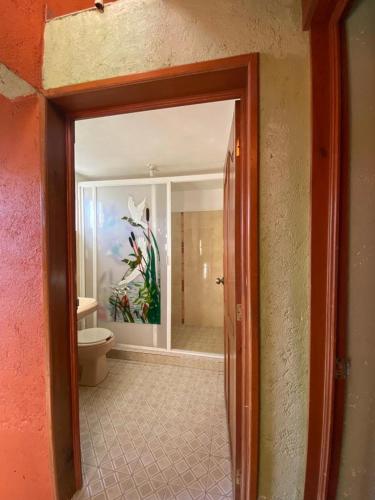 an open door to a bathroom with a toilet at Cabañas y Habitaciones El Malecón in Zirahuén