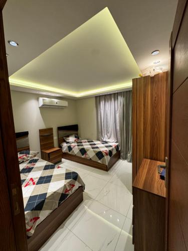 - une chambre avec deux lits et un plafond dans l'établissement Bright apartment ( شقة واسعة من 3 غرف ), au Caire