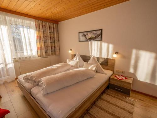 a bedroom with a large bed with white sheets at Ferienwohnung Krimbacher in Brixen im Thale
