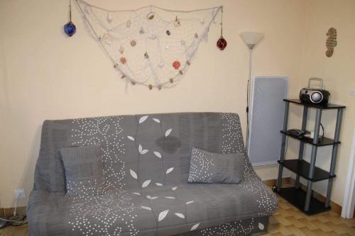 - un salon avec un canapé gris et un mur dans l'établissement Studio cap Agde, au Cap d'Agde