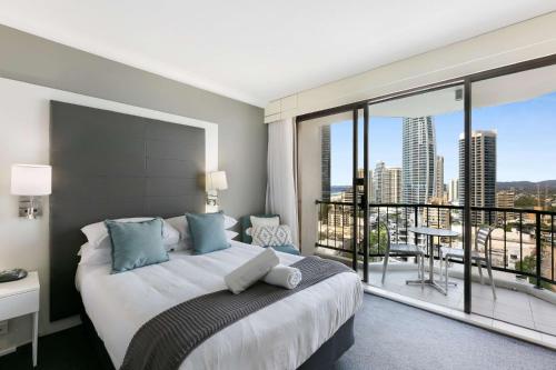 a bedroom with a large bed and a large window at Sleek and Central Studio Apartment in Gold Coast